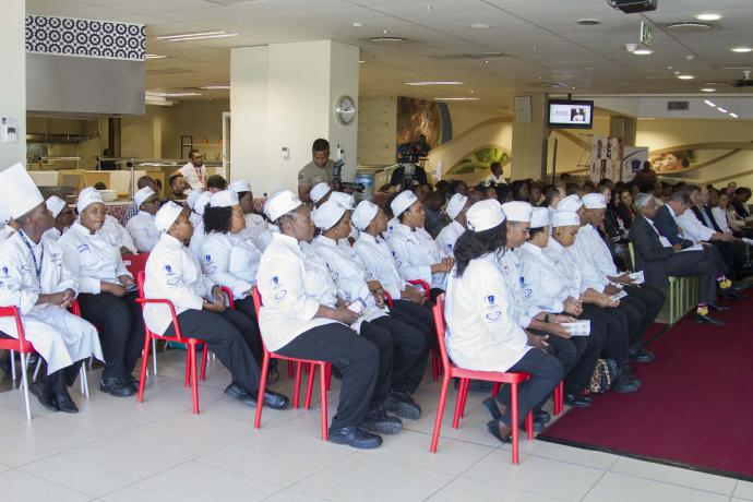 Culinary Education programme with dozens of Chefs sitting at a convention.
