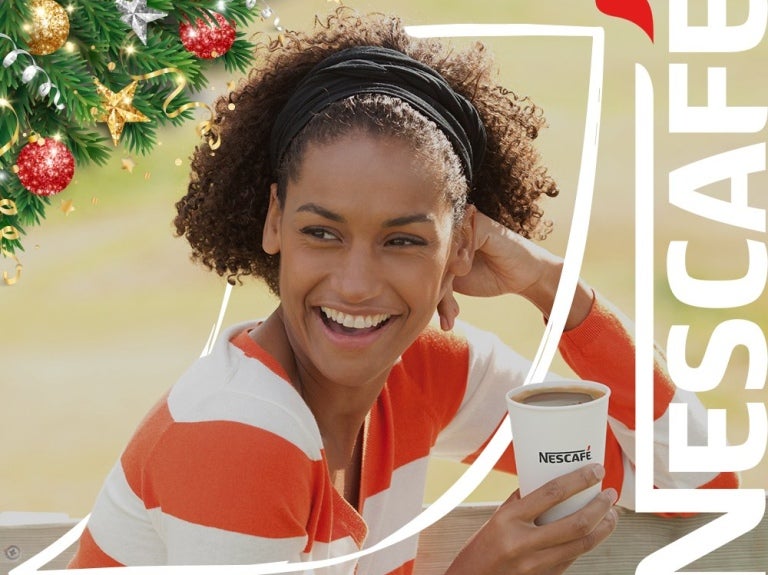 Person holding a Nescafé coffee cup